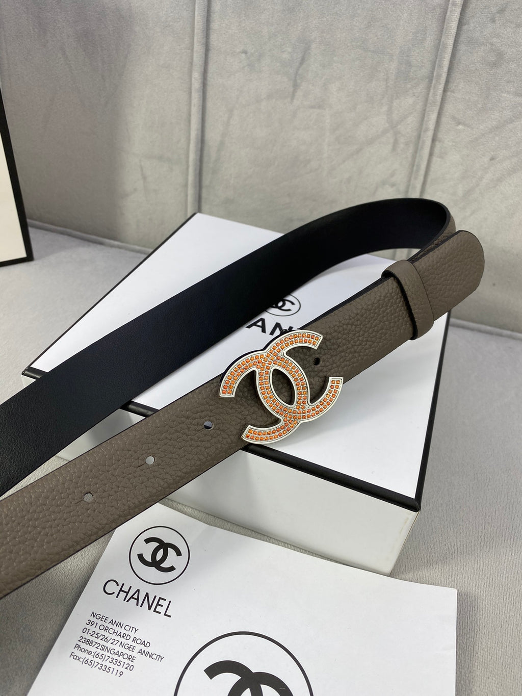 Chanel belt showing length and gold CC logo buckle on dark taupe leather