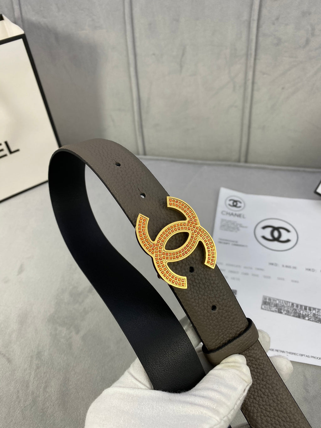 Chanel leather belt from side angle with dark taupe strap and gold CC buckle