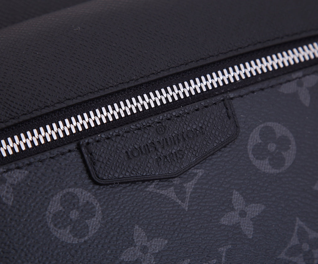 Louis Vuitton bag front tab label and silver zipper along textured dark fabric