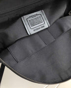 Coah bag interior label area with black fabric lining and stitched seams