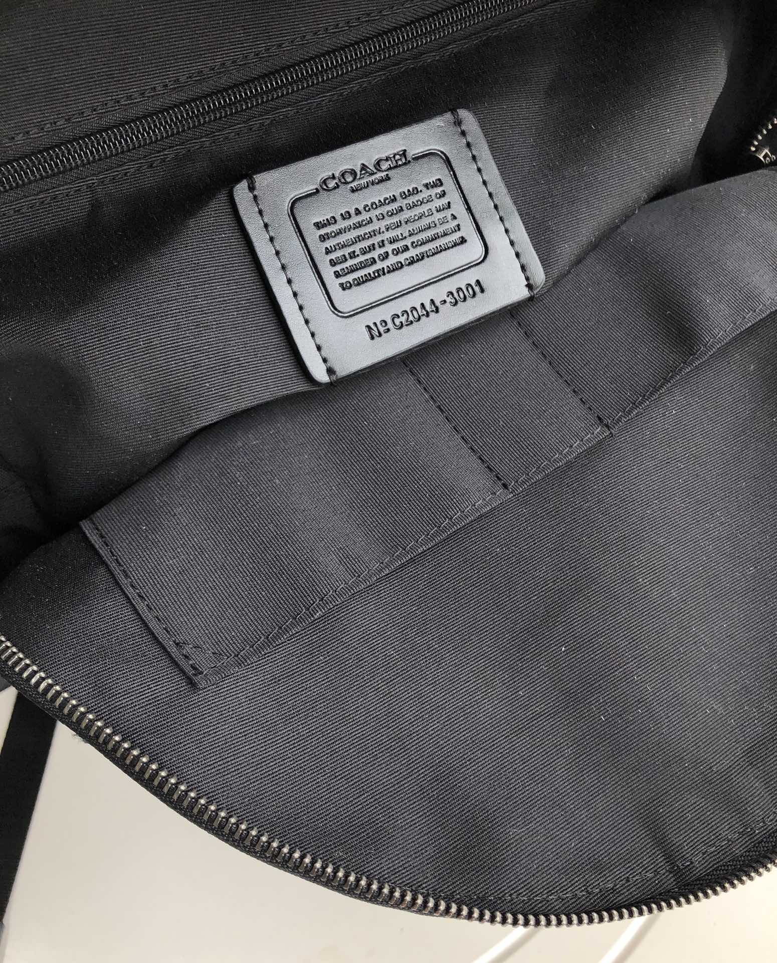 Coah bag interior label area with black fabric lining and stitched seams