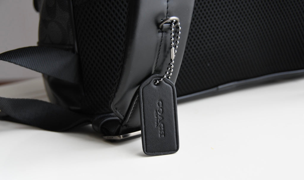 Coah bag close-up of adjustable strap and front corner with zipper pull
