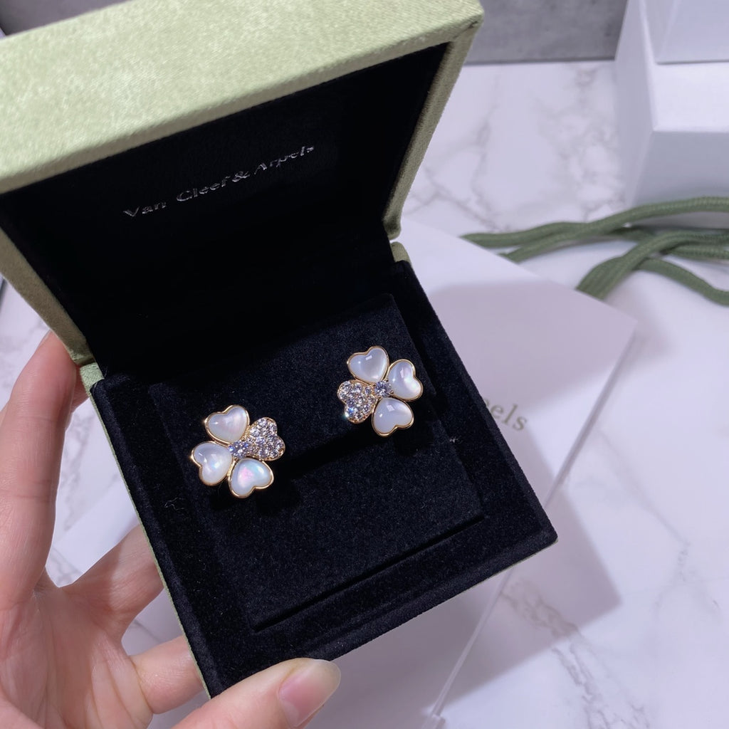 Pair of flower stud earrings in gold tone with pastel blue petals and crystal detailing