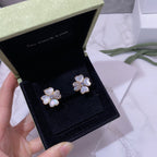 Pair of flower stud earrings in gold tone with pastel blue petals and crystal detailing