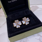 Pair of flower-shaped stud earrings in gold tone with pastel blue petals and crystals