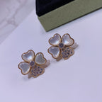 Close-up of two flower stud earrings; gold tone with pastel blue petal hearts and crystals