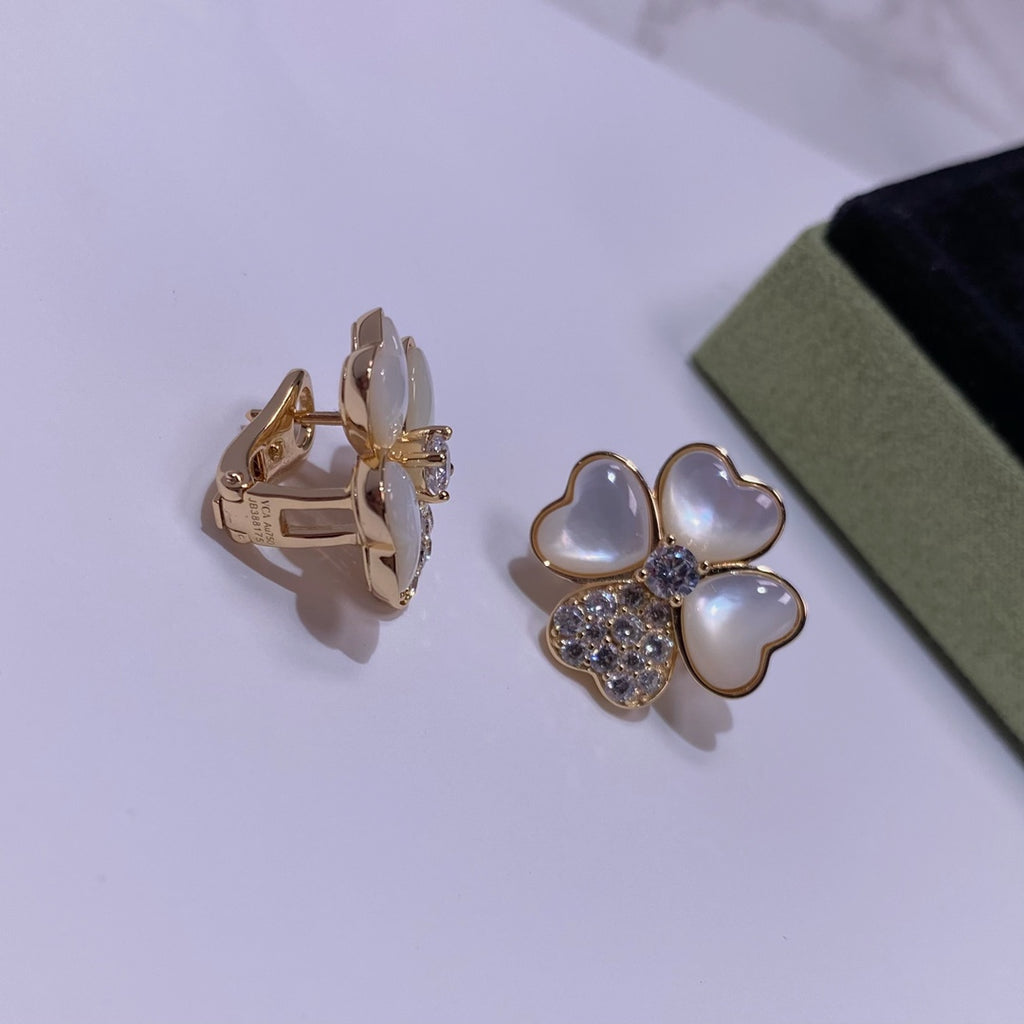 Pair of gold-tone stud earrings with pastel blue petal hearts and crystal center