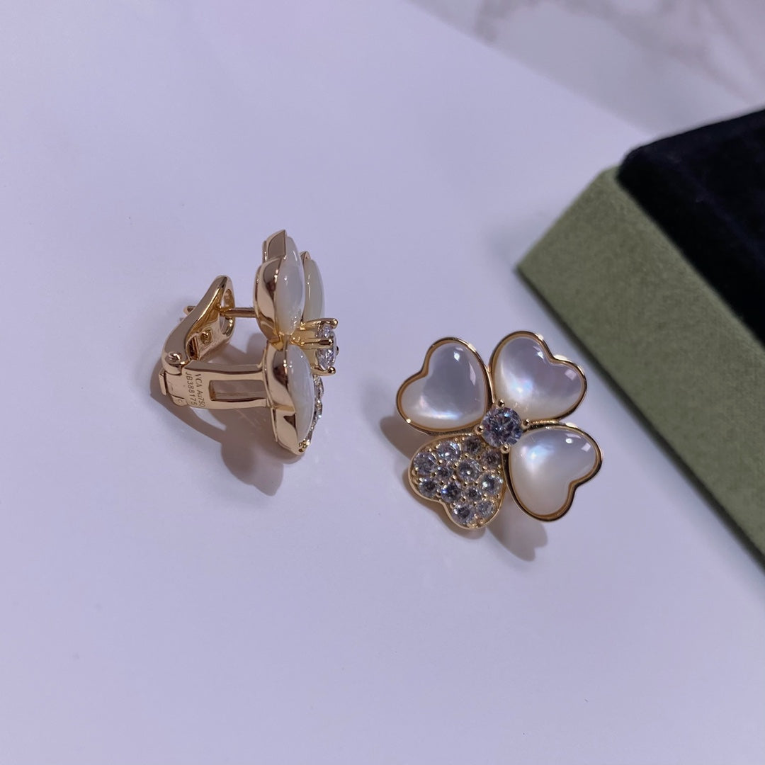 Pair of gold-tone stud earrings with pastel blue petal hearts and crystal center