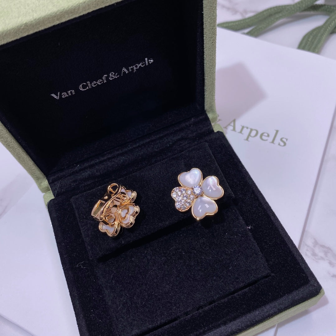 Pair of flower-shaped stud earrings in gold tone with pastel blue petals and crystal pavé
