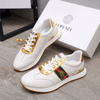 Pair of white lace-up sneakers with gold-trim details and multicolor side patch