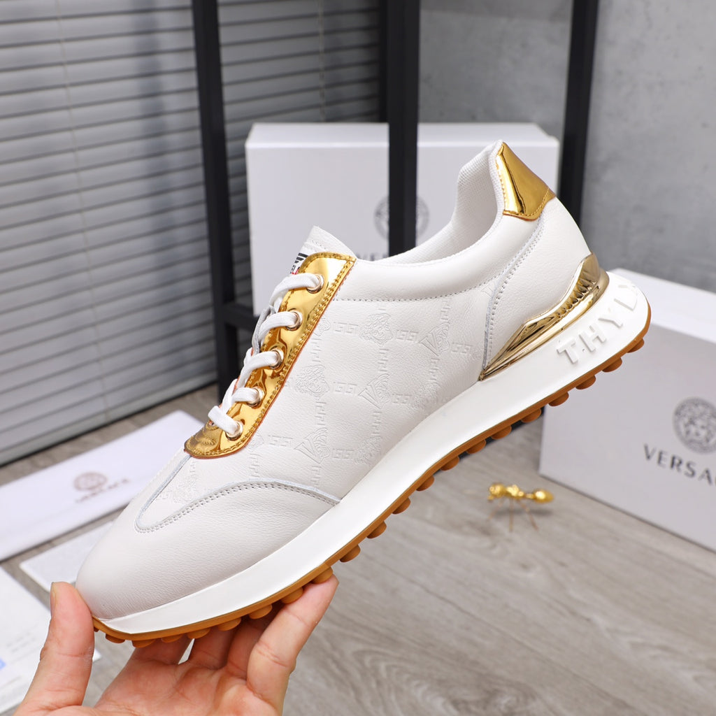 White sneakers with gold trim, lace-up front, and chunky sole