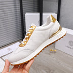 White sneakers with gold trim, lace-up front, and chunky sole