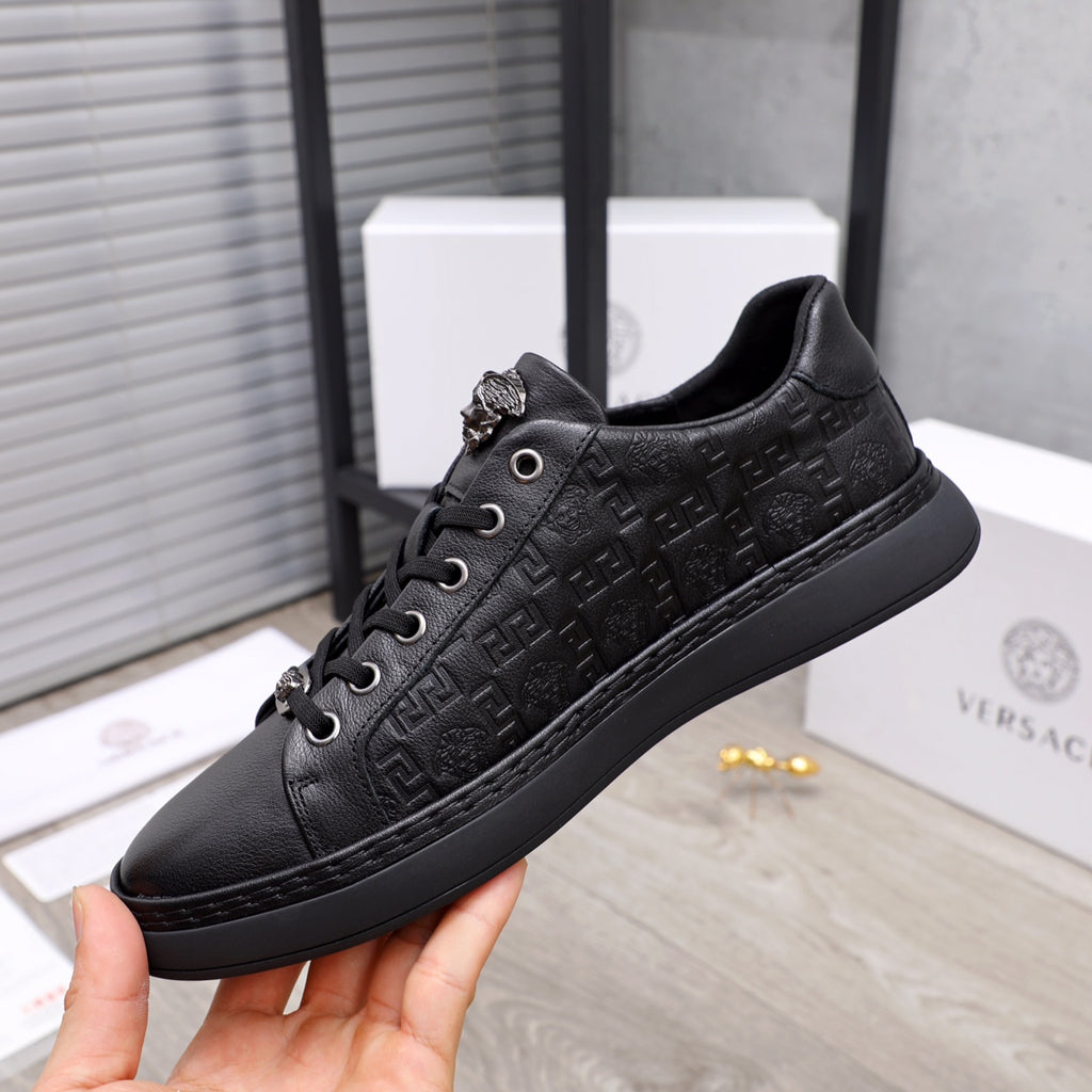 Black Versace lace-up sneakers with embossed monogram finish and dark rubber sole