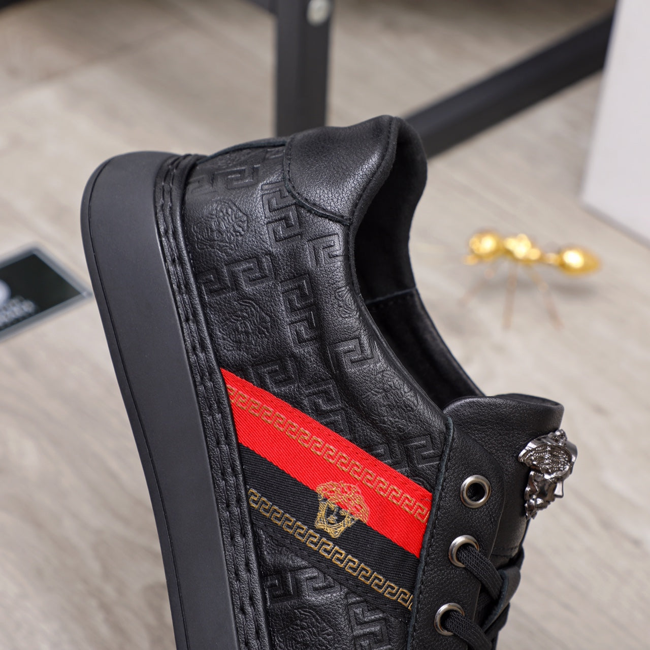 Black Versace lace-up sneakers with embossed pattern and red side stripe on quarter