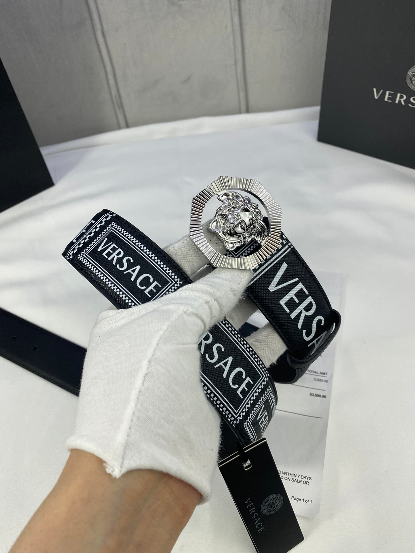 Versace belt with black-and-white logo strap and silver-toned medallion buckle