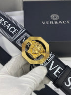 Versace belt strap with black-and-white logo weave and gold-toned medallion buckle close-up