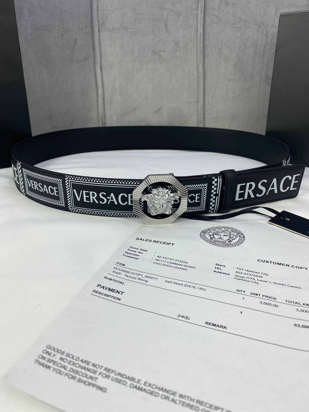 Versace belt laid flat in black with logo weave and silver-toned medallion buckle
