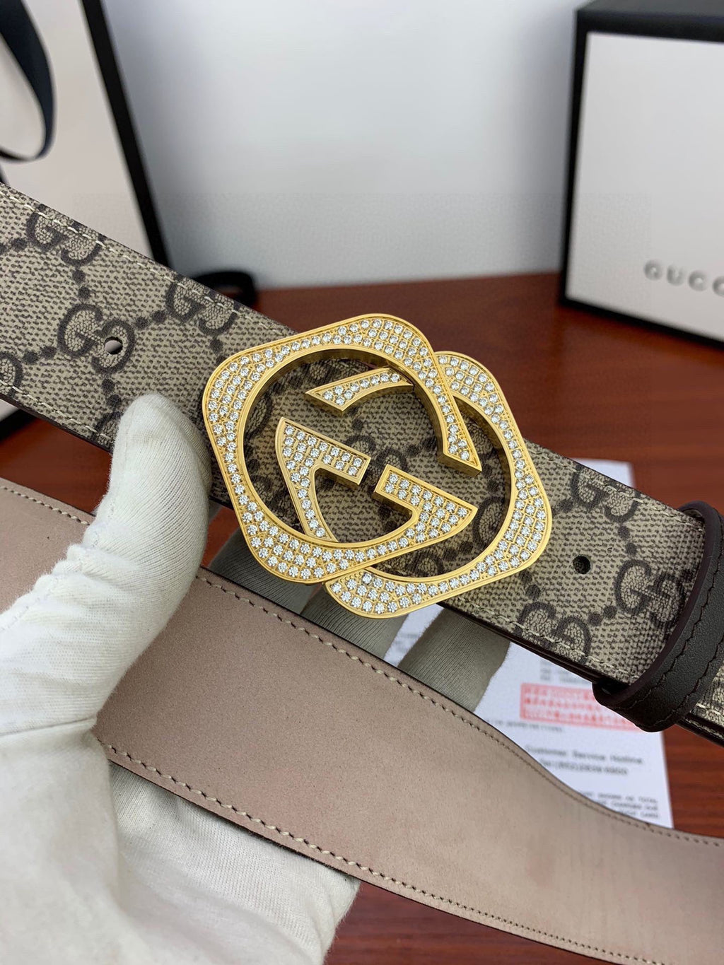 Gucci belt close-up: beige GG canvas with gold-tone crystal-studded double G buckle