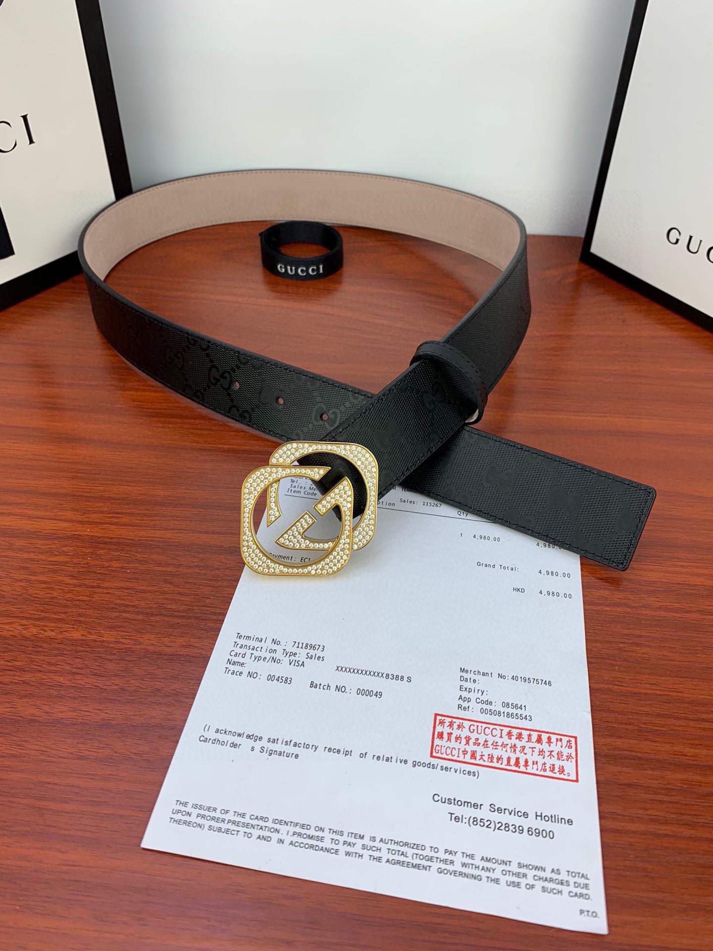 Gucci belt with black strap, gold-tone GG buckle, belt holes at the tip