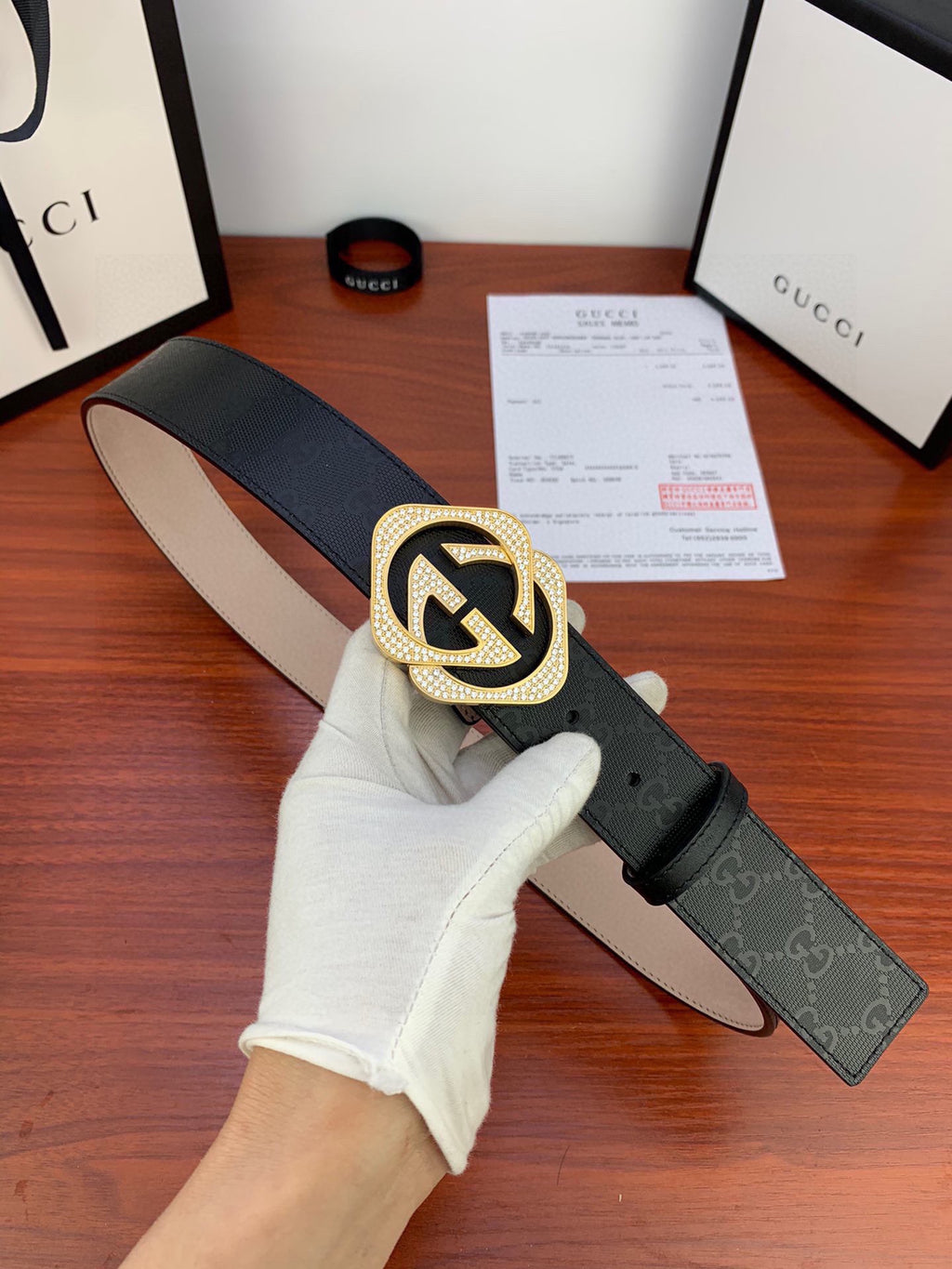 Gucci belt with black strap and gold-tone GG buckle, adjustable end visible