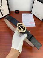 Gucci belt with black strap and gold-tone GG buckle, adjustable end visible