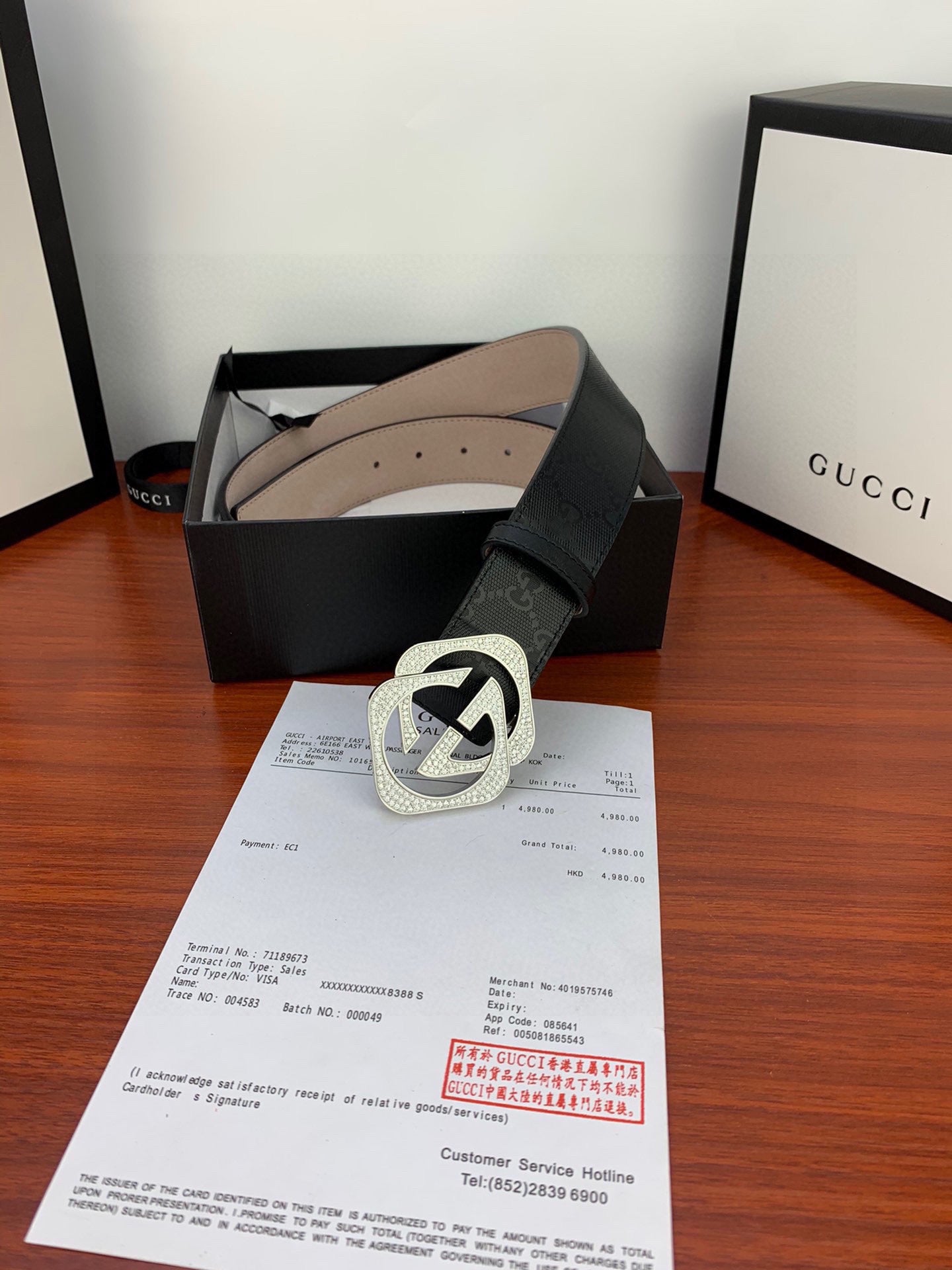 Gucci belt with black strap and silver-tone GG logo buckle on a grained band