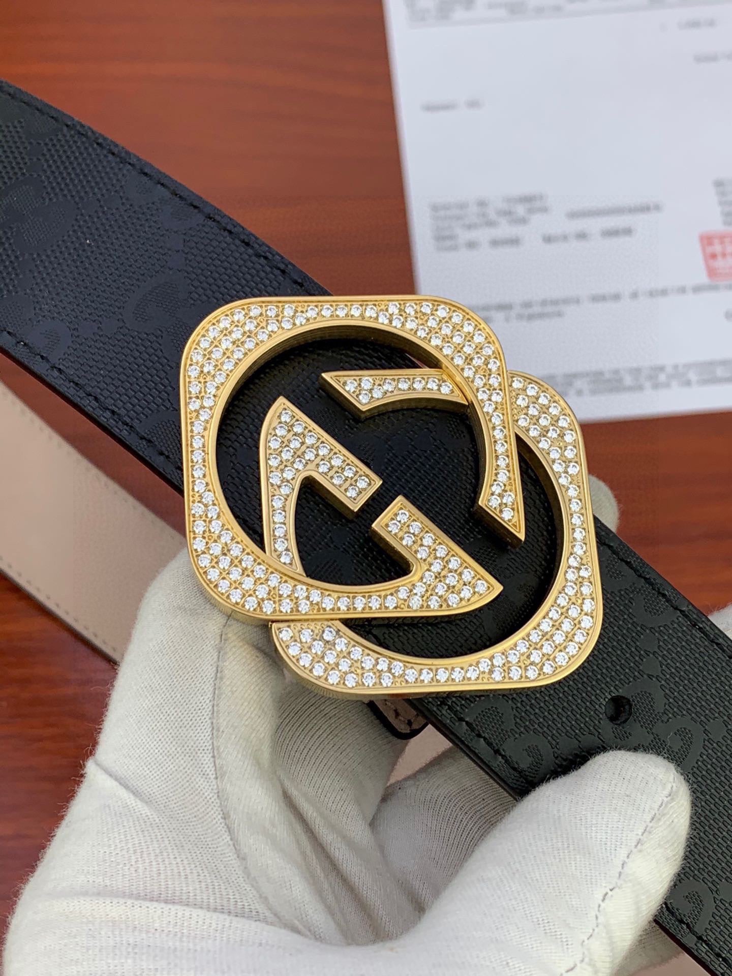 Gucci belt buckle close-up with crystal-studded GG logo on black strap