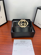 Gucci belt with black strap and GG buckle, gold-tone ring with glittering border