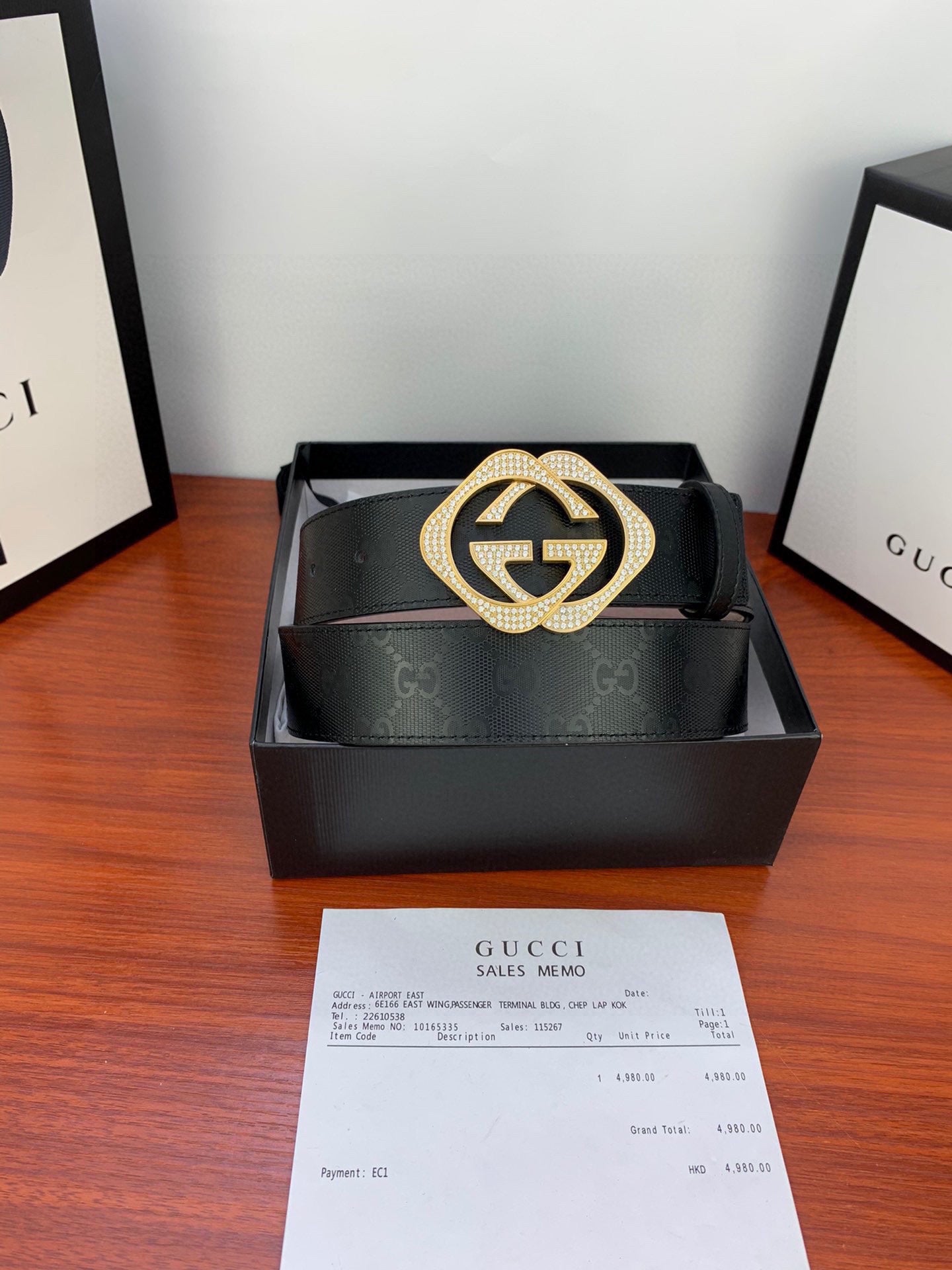 Gucci belt with black strap and GG buckle, gold-tone ring with glittering border