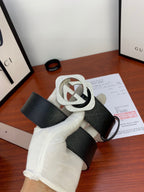 Gucci belt with dark patterned strap and silver-tone GG buckle, end tab visible