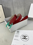 Red leather belt with teal CC-logo buckle, coiled in box with tag