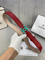 Red leather belt with teal CC-logo buckle, side view with tan underside