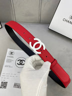 Red leather Chanel belt with white CC logo buckle, visible holes