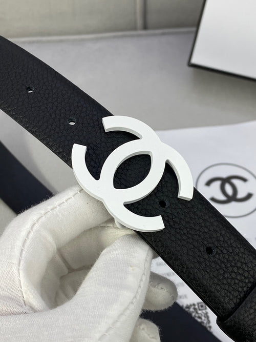Chanel belt close-up, black textured strap with silver CC buckle and punched holes.