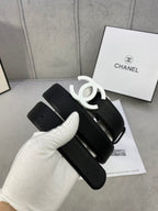 Chanel belt, black textured strap with silver CC buckle and looped strap end.