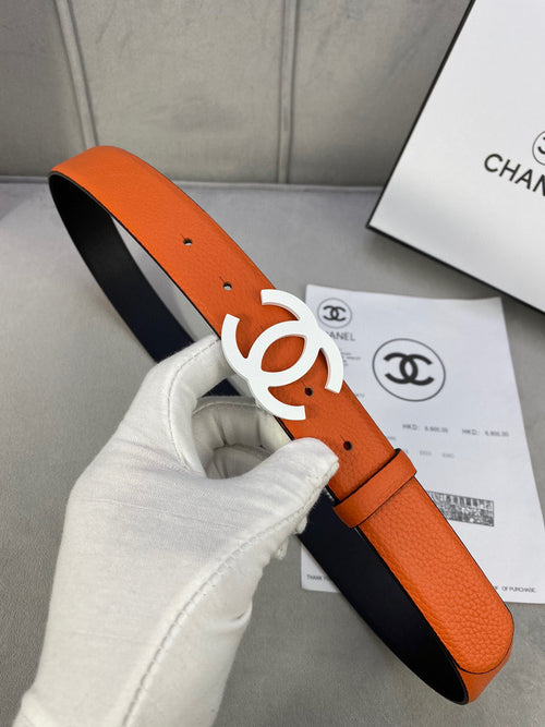 Chanel leather belt with orange strap, navy underside, and white CC buckle