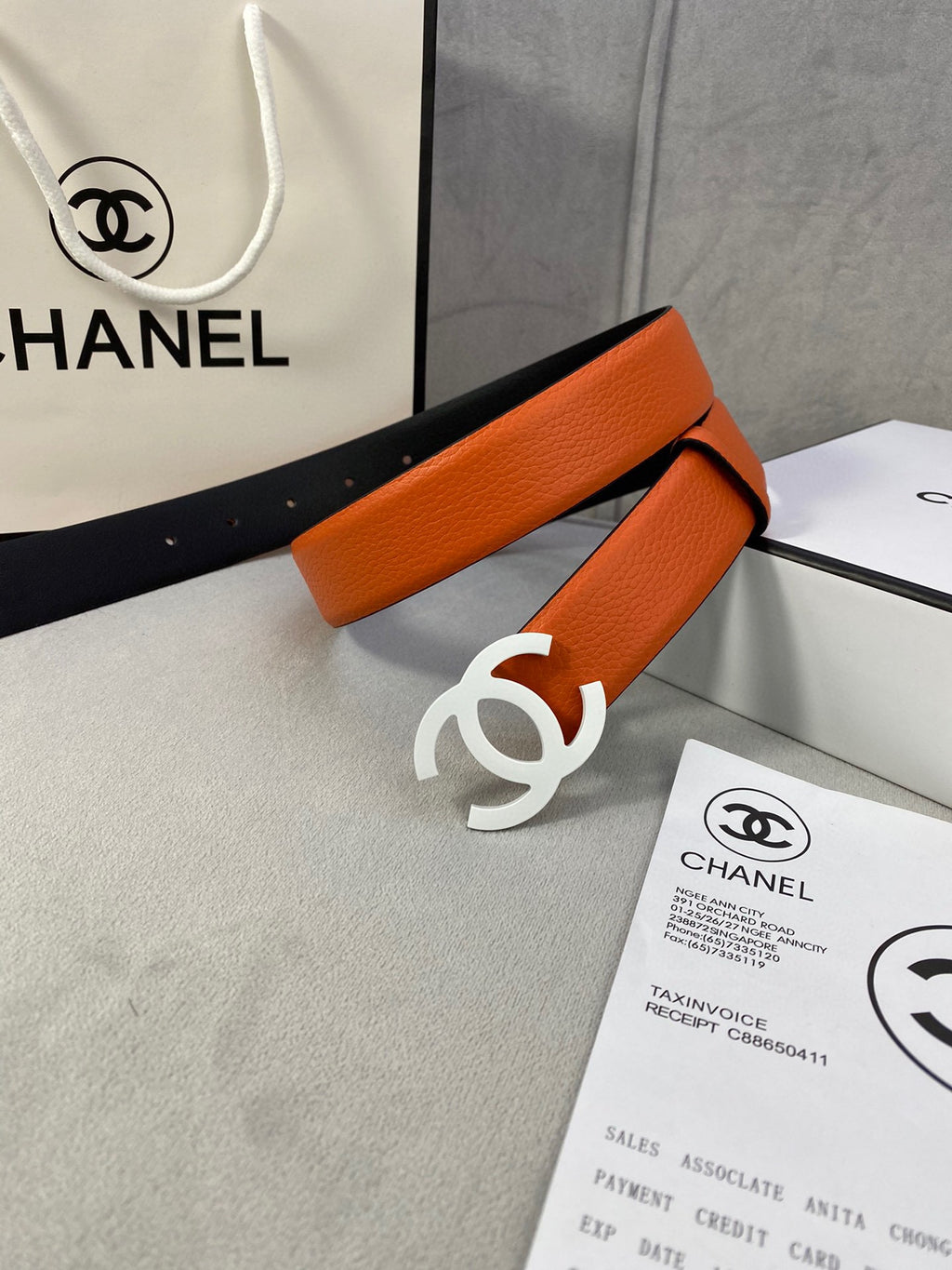 Chanel leather belt with orange strap and white CC buckle on black lining