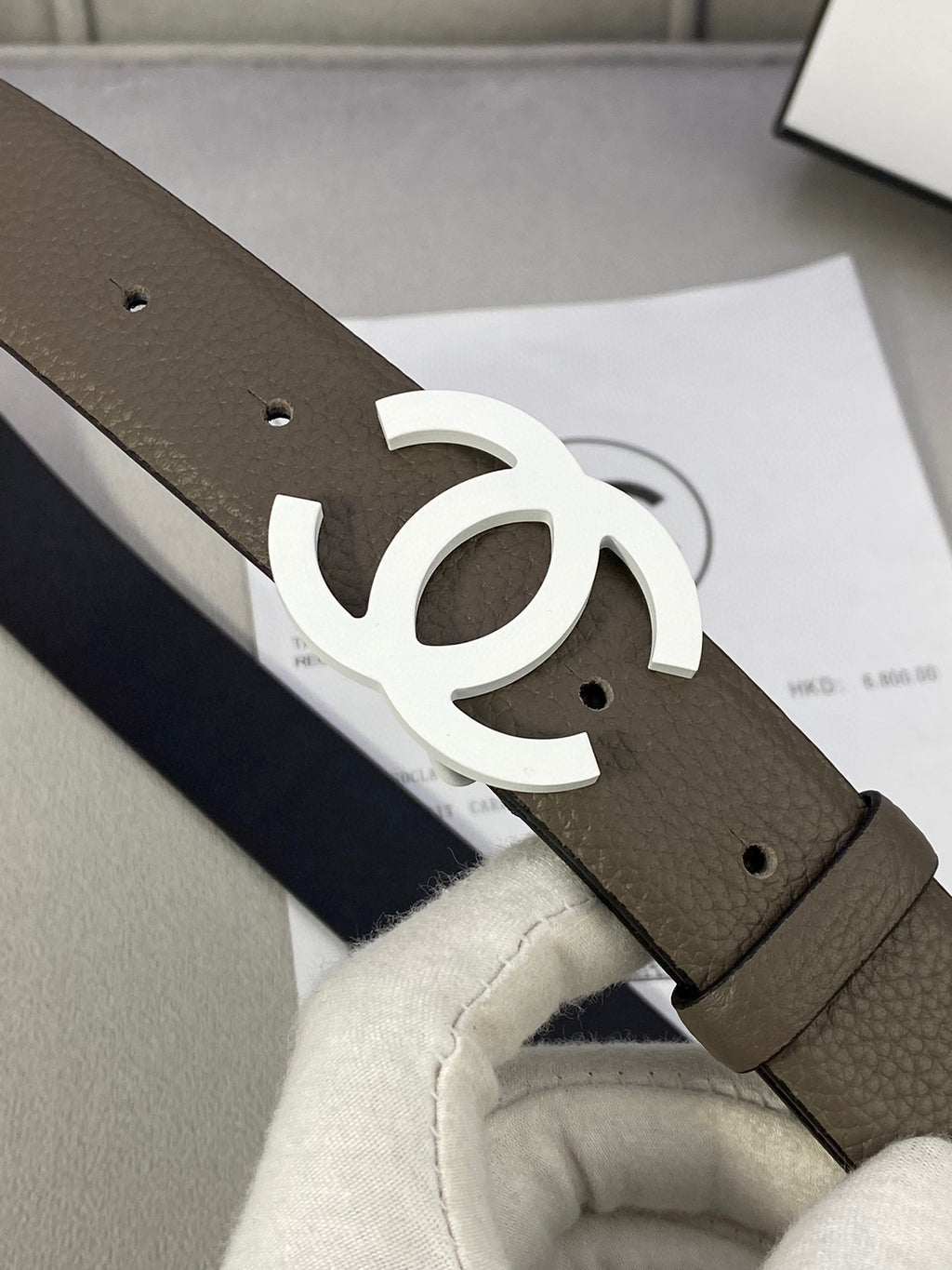 Dark olive leather belt with silver-tone interlocking CC buckle close-up