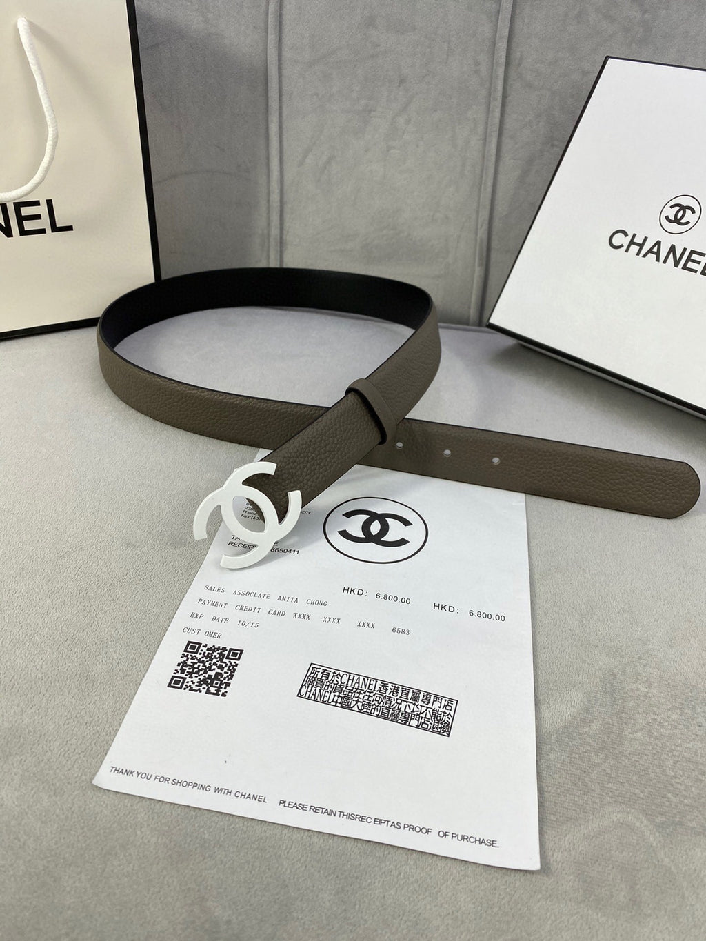 Dark olive leather belt with silver-tone interlocking CC buckle, looped view