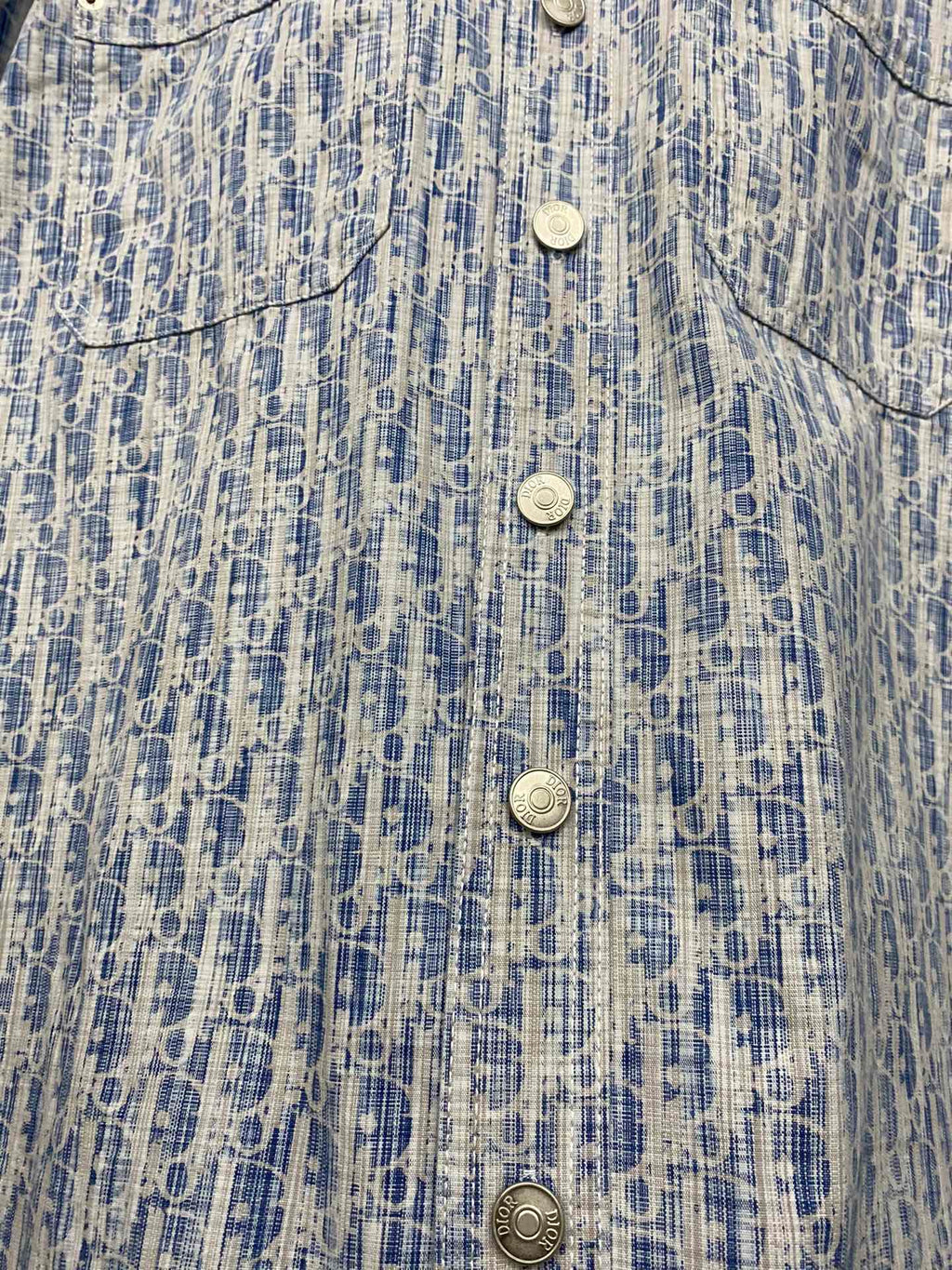 Blue and white patterned shirt front close-up with four snap-style buttons