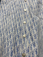 Blue and white patterned shirt front close-up with four snap-style buttons
