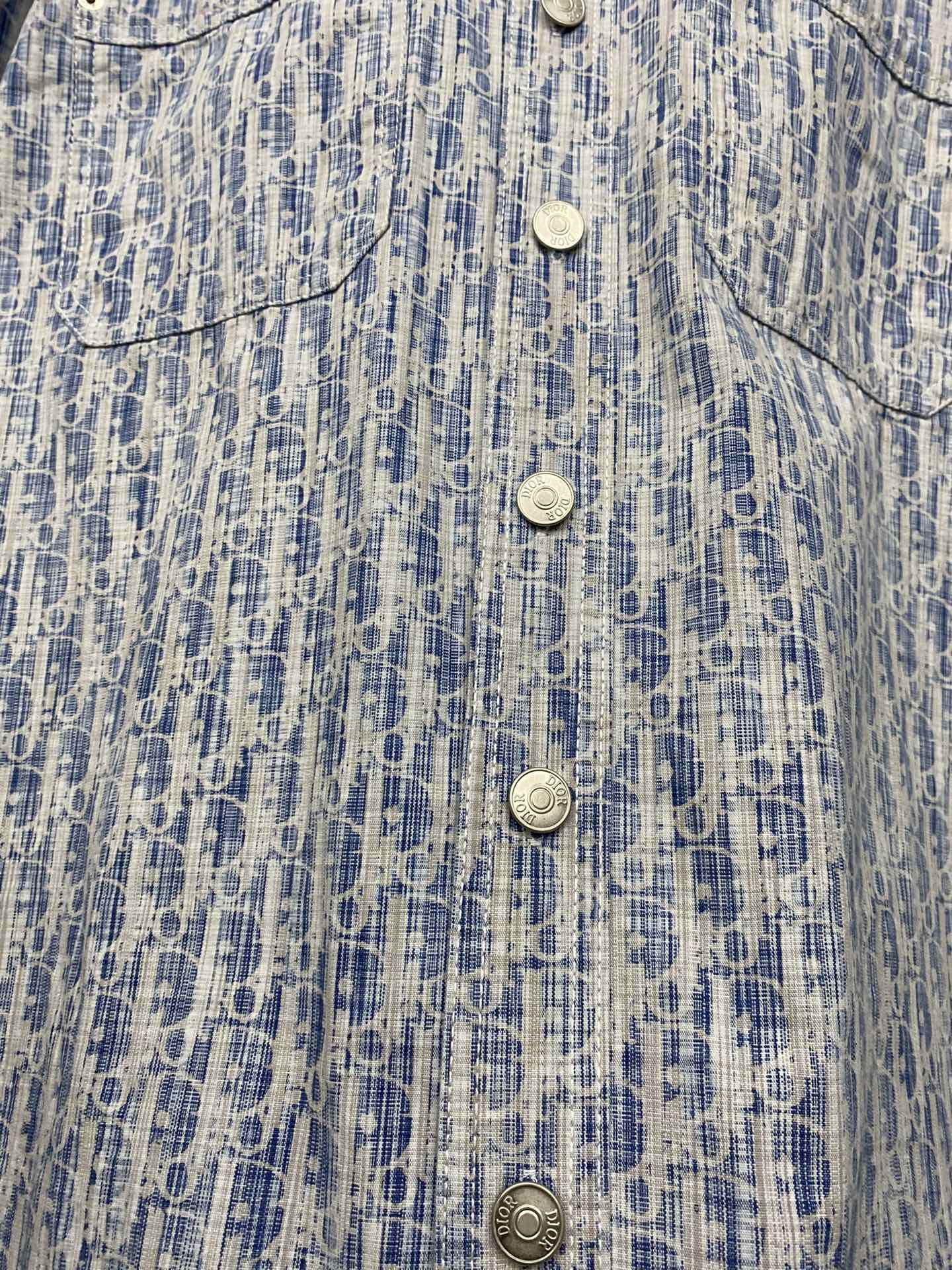 Blue and white patterned shirt front close-up with four snap-style buttons
