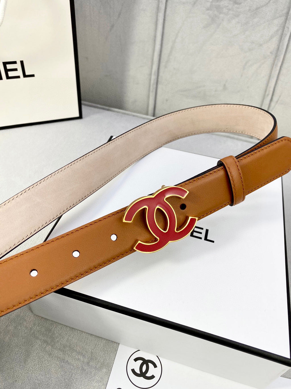 Brown Chanel belt detail with red CC logo buckle and leather strap