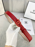 Red leather belt held in hand, with Chanel CC logo buckle and gold-tone hardware