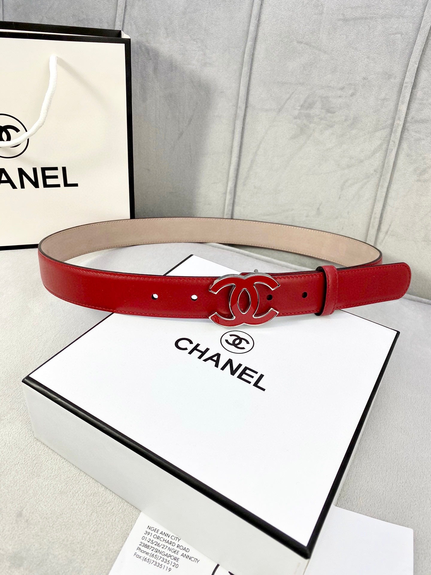 Red leather belt with Chanel CC logo buckle and gold-tone hardware, punched holes
