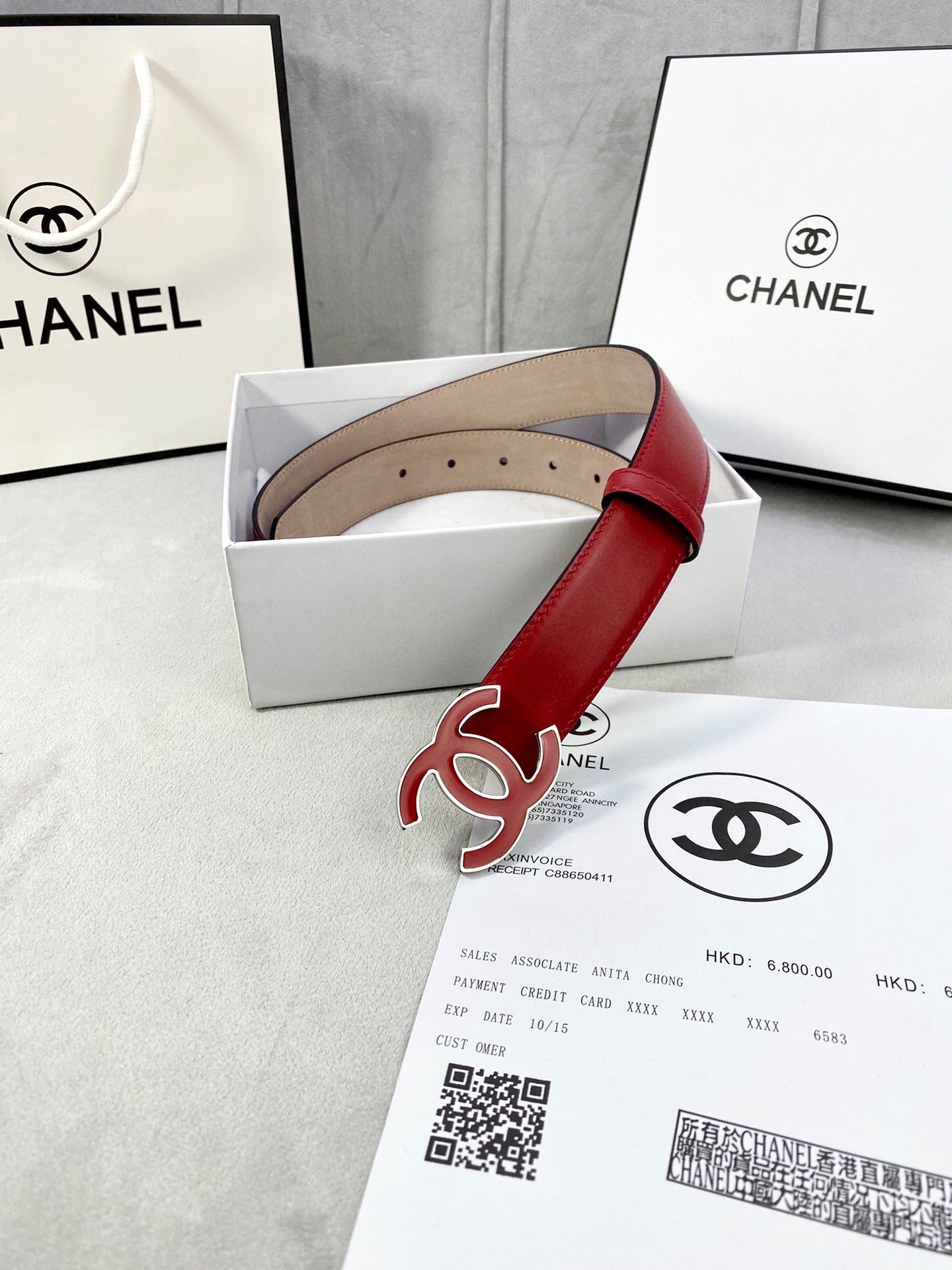 Red leather belt with Chanel CC logo buckle and gold-tone hardware, packaged