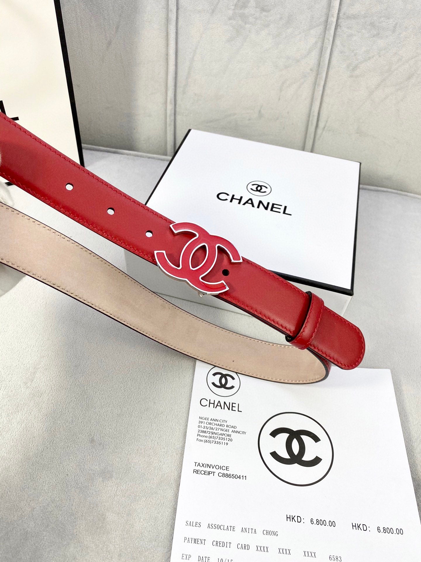Red leather belt with Chanel CC logo buckle and gold-tone hardware, side view