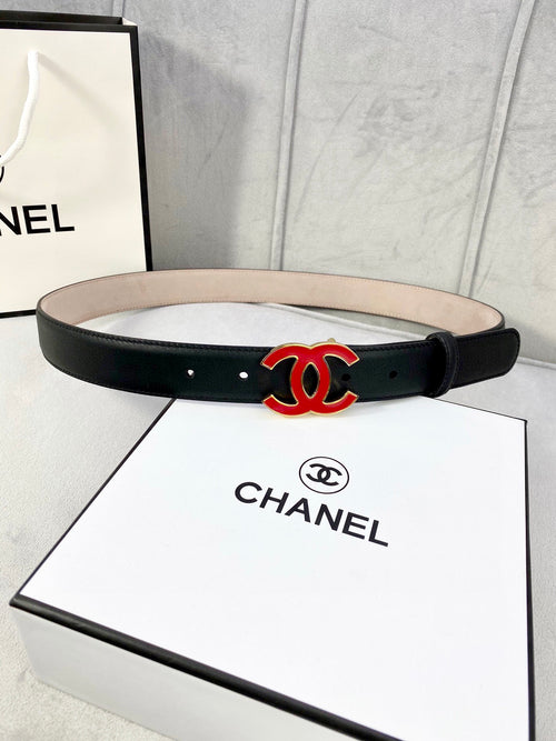 Chanel belt in dark leather with red-and-black CC logo at center, flat strap.