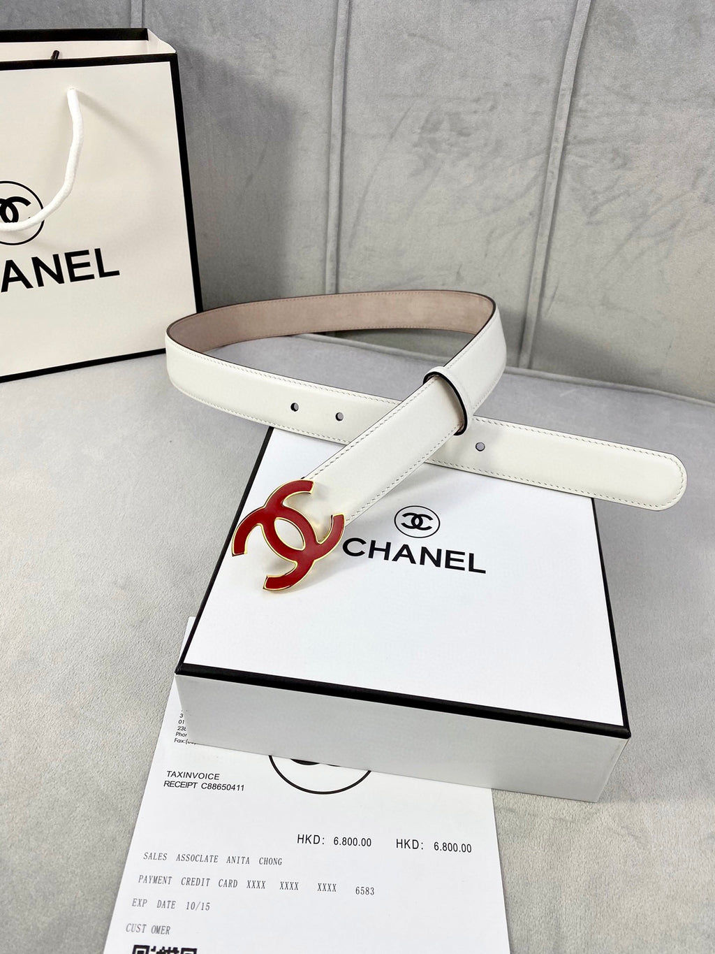 White Chanel belt with red logo buckle and tan underside