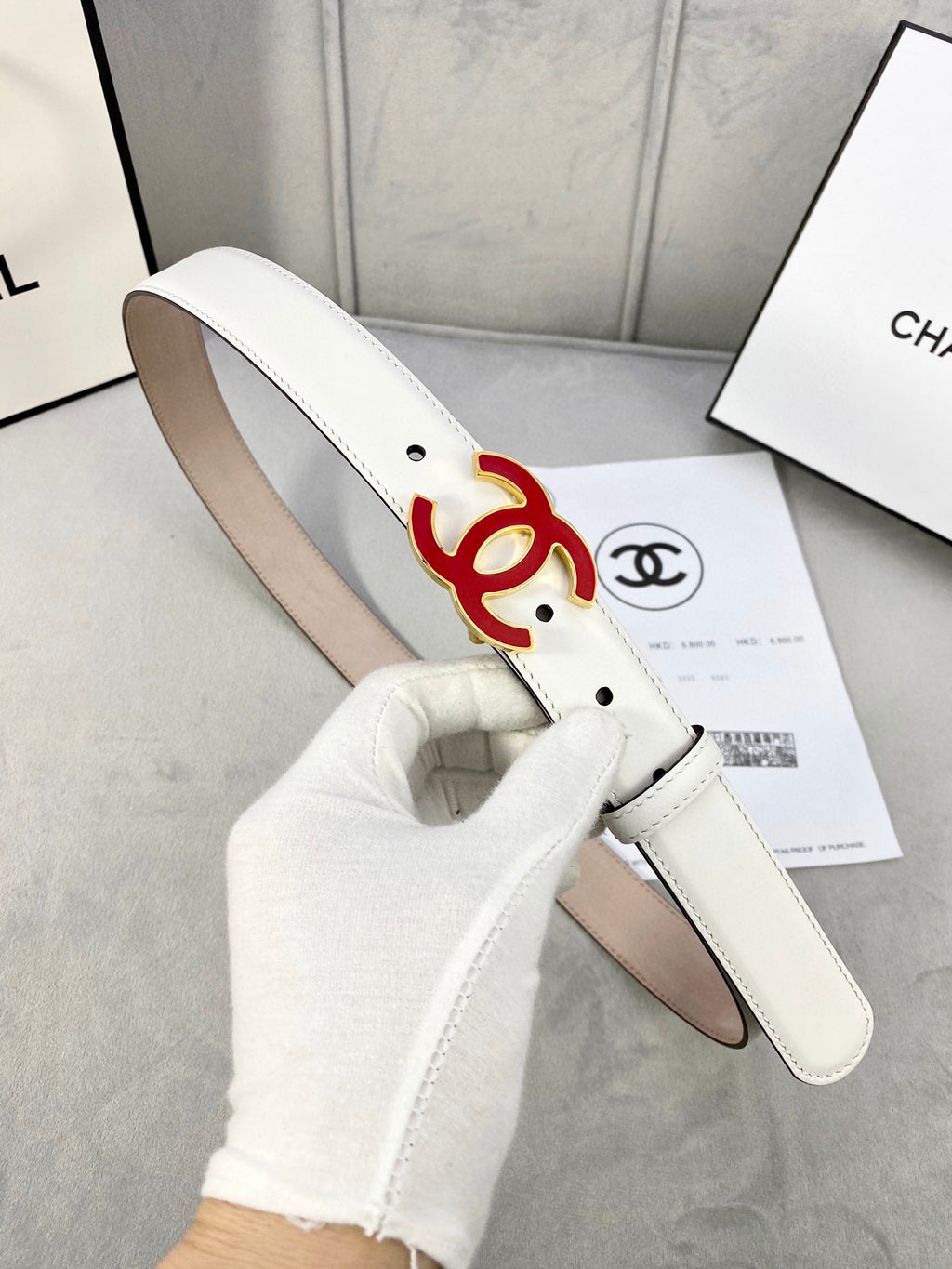 White Chanel belt with red logo emblem buckle and leather strap